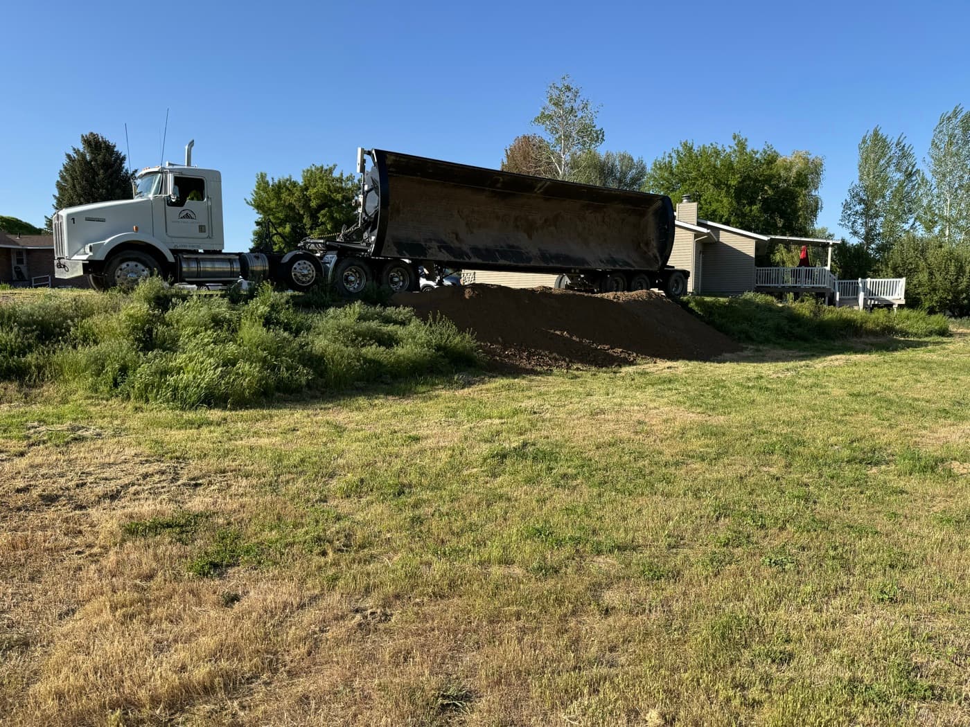Silver Creek Logistics truck delivering topsoil at a Magic Valley job site